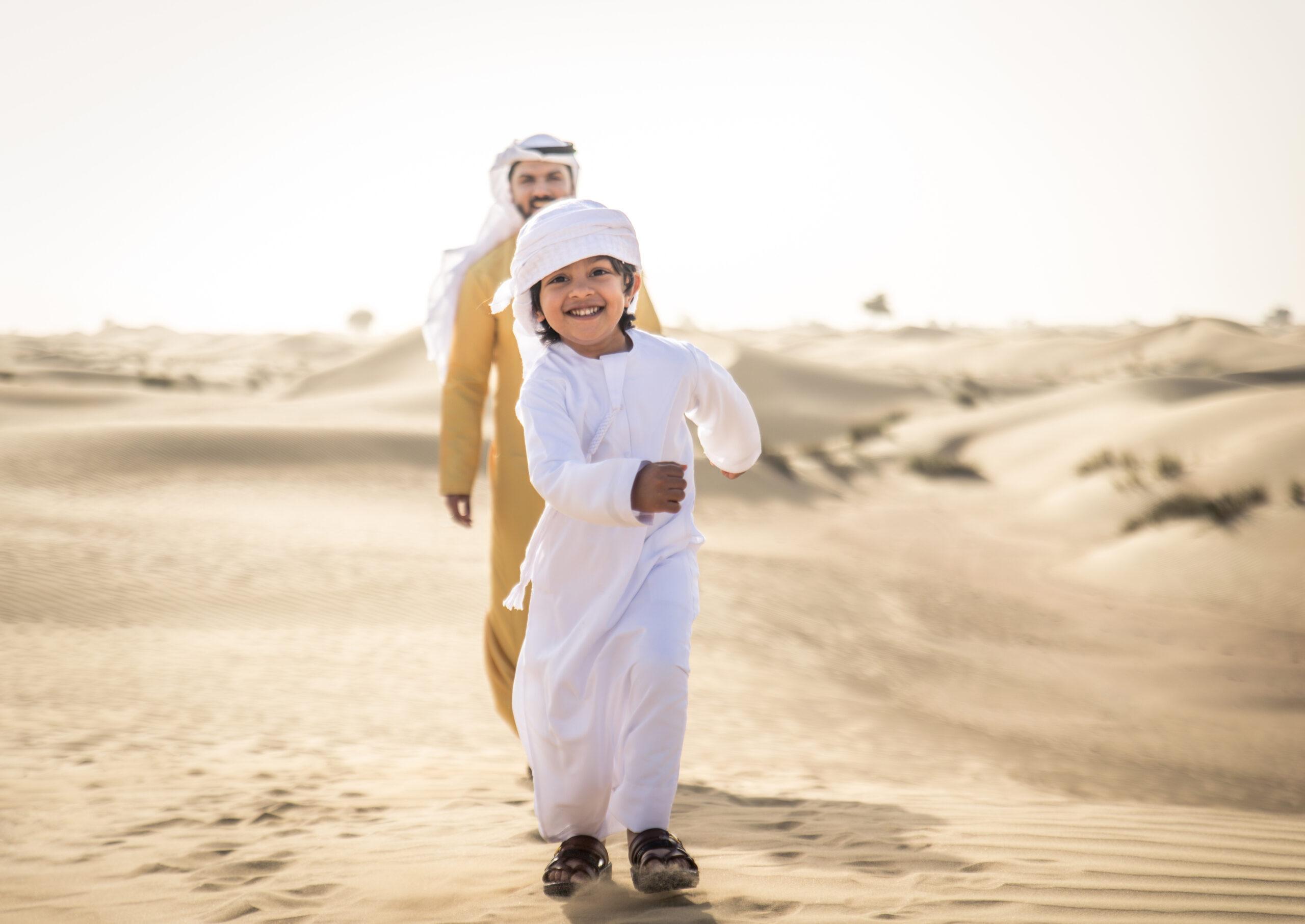 Arabian man and son playing in the desert